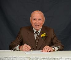 Abe Simkin signs his story for the Jewish Foundation's Endowment Book of Life
